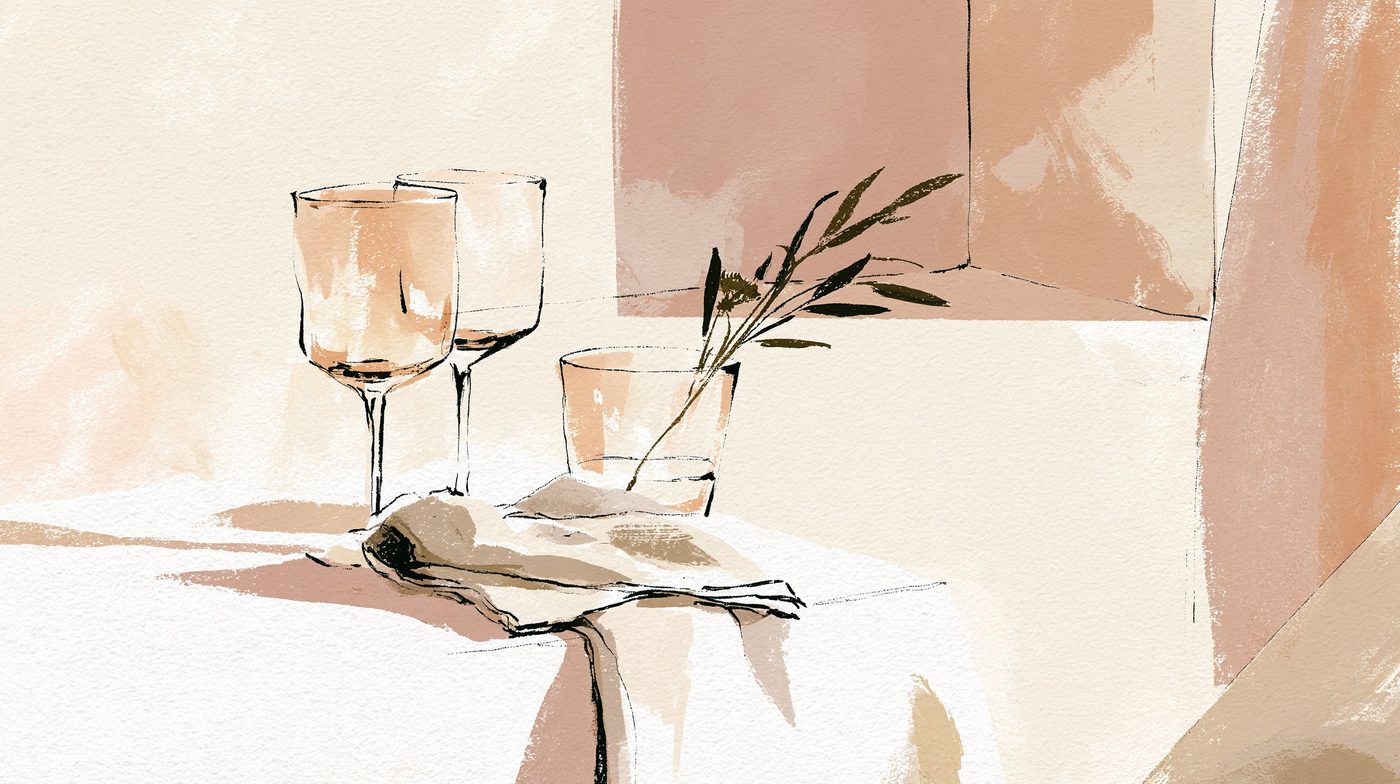 A Shabbos table laid with wine glasses, a folded napkin and a sprig of rosemary